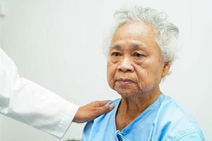 Doctor taking care, help and encourage Asian elder senior woman patient in clinic hospital. photo