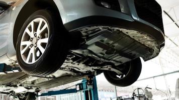 Car on the Lift Up Machine at the Car Repair Station. Fixing Services and Maintenance. Selective Focus photo