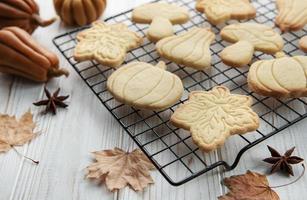 galletas con forma de calabaza y hojas sobre fondo de madera rústica foto