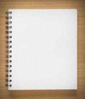 blank spiral notebook on wood background photo