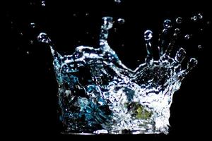 Splashing water on a black background. water droplets scattered on a black background photo