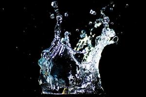 Splashing water on a black background. water droplets scattered on a black background photo
