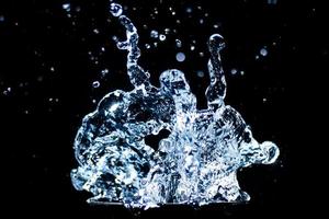 Splashing water on a black background. water droplets scattered on a black background photo