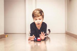 Cute kid playing with car toys on the floor. photo