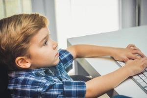 Little boy typing on computer keyboard. photo