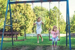 Small girls swinging in the park. photo