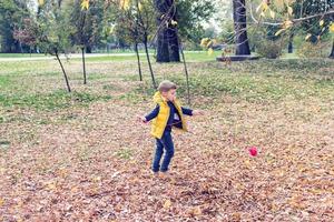 Playful kid having fun in fall season. photo