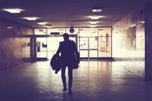 Silhouette of man walking through an empty hallway. photo