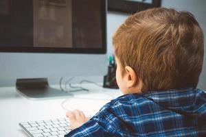 Close up of little boy using computer. photo