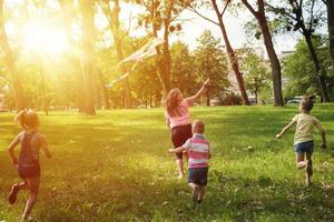 niños juguetones volando cometas en el día de verano. foto