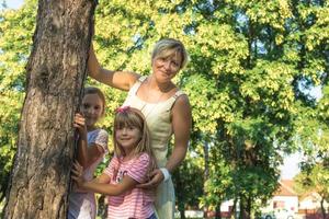 madre feliz con hijas en el parque. foto