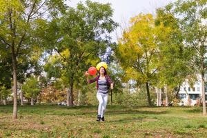 Playful woman running with balloons in the park. photo