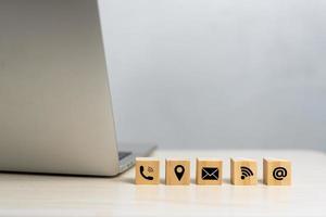 wood cube icon website page contact us or e-mail call phone, address, marketing concept on desk. photo