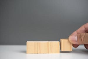 hand holding cube wood block blank on background. copy space photo