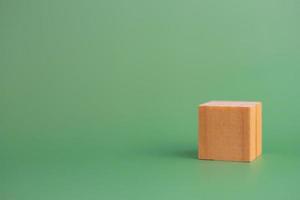 bloque de madera de cubo en blanco sobre fondo verde. copie el espacio