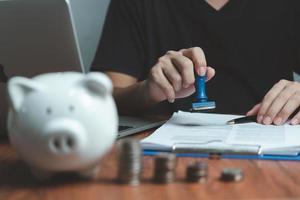 Man stamping approval of work finance banking or investment marketing documents on desk. photo