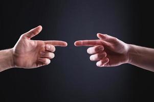 Two men's hands point at each other with index fingers. The concept of mutual understanding between men expressed in hand gestures photo