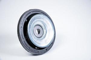 New thrust bearing of front suspension strut of a car on a gray background. The concept of new spare parts and replacement parts in service centers photo