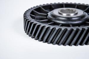 Black polymer gear camshaft with metal base. New spare part for an internal combustion engine on a gray background photo