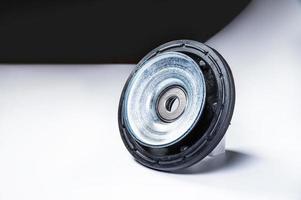 New thrust bearing of front suspension strut of a car on a gray background. The concept of new spare parts and replacement parts in service centers photo