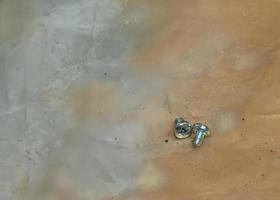 Two mounting bolts on the work surface. Close-up photo