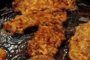 Beef chops in a pan on the stove. The process of preparing beef chops in batter photo