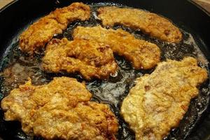 Beef chops in a pan on the stove. The process of preparing beef chops in batter photo