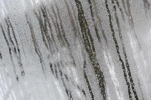 The texture of a misted glass with a lot of drops and condensation flows. Background image photo
