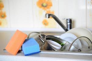 A few sponges lie on the background of the sink with dirty dishes photo