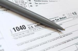 el bolígrafo se encuentra en el formulario de impuestos 1040 us declaración de impuestos sobre la renta individual. la hora de pagar impuestos foto