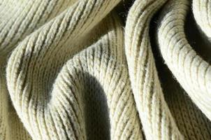 Fabric texture of a soft yellow knitted sweater. Macro image of the structure of bindings in yarns photo