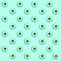 Many small plastic donuts lies on a pastel colorful background. Flat lay minimal pattern. Top view photo