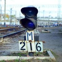 semáforo con luz azul ardiente. la intersección de las vías del tren foto