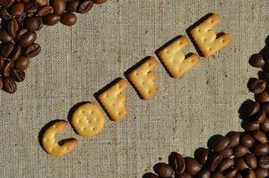 Coffee. The word from the edible letters lies on the gray canvas with coffee beans photo