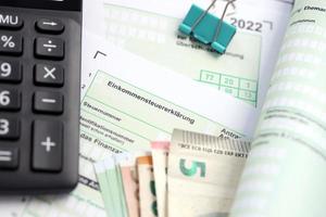 German income tax return form with european euro money bills and calculator lies on accountant table close up. The concept of taxpaying period in Germany photo