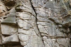 Light coarse natural rock stone background. Mining cliff rough front surface. Big limestone stack backdrop. Heavy grunge damaged granite block texture photo