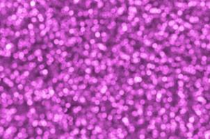 Blurred pink decorative sequins. Background image with shiny bokeh lights from small elements photo