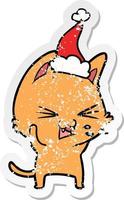 distressed sticker cartoon of a cat hissing wearing santa hat vector