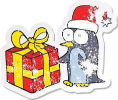 retro distressed sticker of a cartoon christmas penguin with present vector