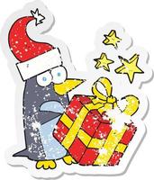 retro distressed sticker of a cartoon christmas penguin with present vector