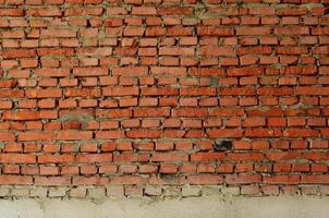 Red brick wall texture grunge background with many rows of bricks, may use to interior design photo