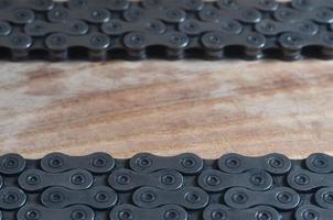 cadena sucia y aceitosa de una bicicleta de montaña sobre una mesa de madera en una tienda de bicicletas foto