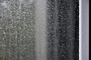 Background image of rain drops on a glass window. Macro photo with shallow depth of field