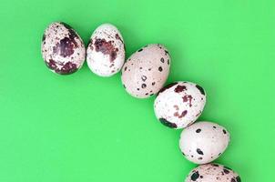 Quail eggs on a light green surface, top view, empty place for t photo