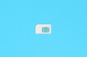 Subscriber identity module. White SIM card on blue background photo