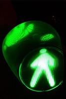 Night photo of a traffic light for pedestrians, which lights up in green