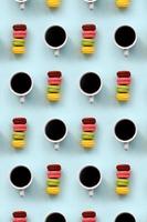 A pattern of many colorful dessert cake macaroon and coffee cups on trendy pastel blue background top view. Flat lay composition photo
