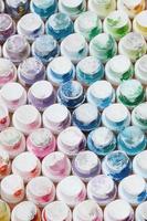 A pattern from a many nozzles from a paint sprayer for drawing graffiti, smeared into different colors. The plastic caps are arranged in many rows forming the color of the rainbow photo