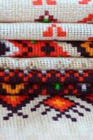 Stack of traditional Ukrainian folk art knitted embroidery patterns on textile fabric photo