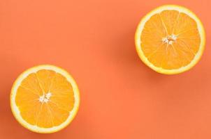 Top view of a several orange fruit slices on bright background in orange color. A saturated citrus texture image photo